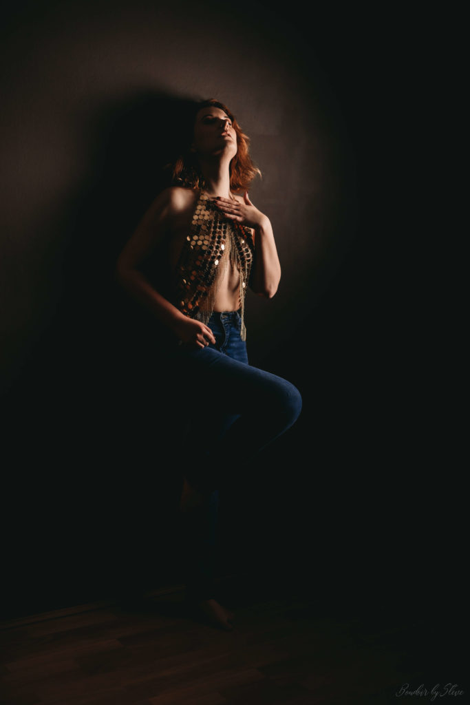 Woman sitting in the shadows, lit by soft light