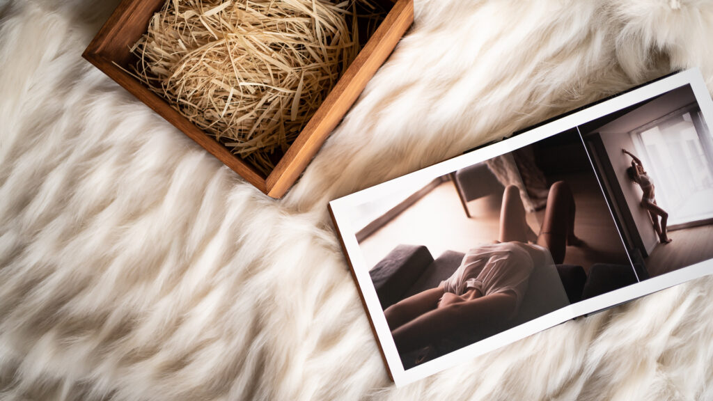 Album photo boudoir ouvert sur une fourrure blanche, à côté de son coffret en bois